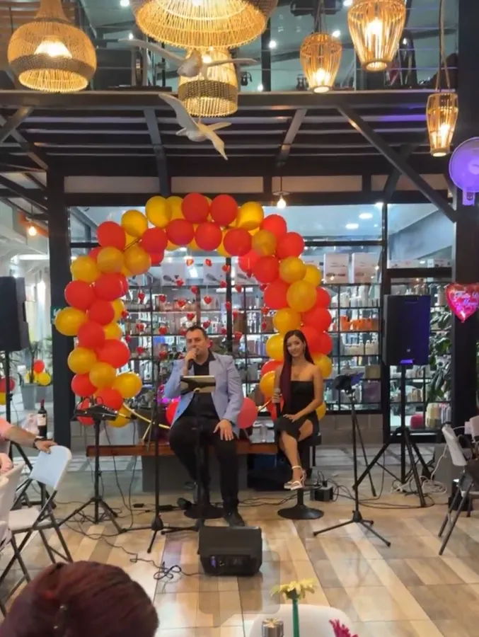SKALA cantando en vivo bajo un arco de globos